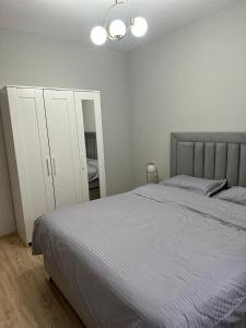 a white bedroom with a bed and a mirror at AlexHome lux apartment 27 free parking in Bucharest