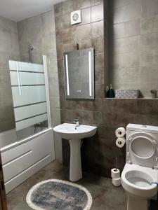 a bathroom with a sink and a toilet and a bath tub at AlexHome lux apartment 27 free parking in Bucharest +21 photos