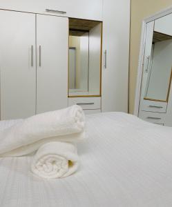 ein weißes Bett mit Handtüchern darauf in der Unterkunft Luna Loft in Mondesa