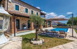 een huis met een zwembad en een tafel en stoelen bij Villa Celine Istria in Radetići +16 foto's