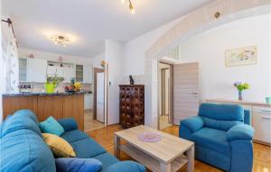 Una sala de estar con un sofá azul y una mesa. en Apartman Magno Mare, en Pula
