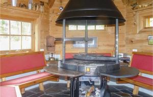 a stove in a wooden cabin with benches and chairs at Hytte Nr 4-156 in Frafjord