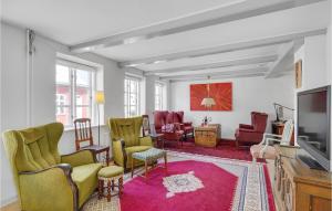 a living room with chairs and a flat screen tv at 3 Bedroom Gorgeous Home In Assens in Assens