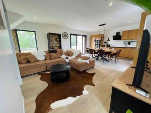 a living room with a couch and a table at Maison avec piscine et cave voûtée in Perrigny-lès-Dijon