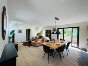 a living room with a table and a couch at Maison avec piscine et cave voûtée in Perrigny-lès-Dijon