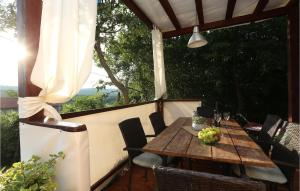 a wooden table and chairs on a porch with grapes on it at Beautiful Home In Ripenda Verbanci in Ripenda Kras +32 photos