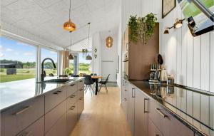 a kitchen with white cabinets and a dining table at 4 Bedroom Beautiful Home In Hemmet in Hemmet
