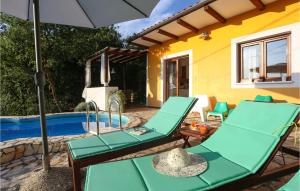 a patio with chairs and an umbrella next to a pool at Beautiful Home In Ripenda Verbanci in Ripenda Kras