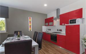 a kitchen with red cabinets and a table with chairs at Stunning Home In Bale in Bale