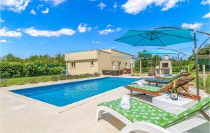 a swimming pool with two lawn chairs and an umbrella at Stunning Home In Bale in Bale +32 photos