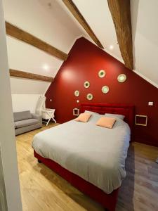 Un dormitorio con una cama grande con una pared roja. en Maison avec piscine et cave voûtée, en Perrigny-lès-Dijon