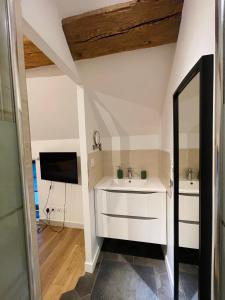 baño con lavabo blanco y TV en Maison avec piscine et cave voûtée, en Perrigny-lès-Dijon