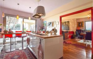 a kitchen and living room with red chairs and a counter at Cozy Home In Calatabiano With Sauna in Calatabiano