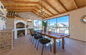 Un comedor con mesa y sillas y chimenea. en Vila Iskra, en Kakma