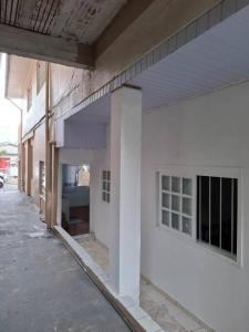 an empty hallway of a white building with windows at Casa Acolhedora 04 no bairro Rio Branco in Caxias do Sul +4 photos