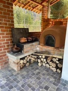 a brick oven with logs and pots and pans at CasaBlanca Callacpuma in Cajamarca