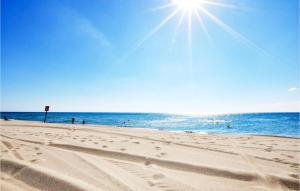 a beach with people in the water and the sun at Gorgeous Home In Perpignan in Perpignan