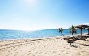 a beach with chairs and umbrellas and the ocean at Gorgeous Home In Perpignan in Perpignan