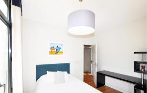 a bedroom with white walls and a bed with a blue headboard at Gorgeous Home In Perpignan in Perpignan