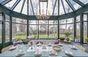 a large conservatory with a table and a chandelier at Au Clos Caleste in Wellin +58 photos