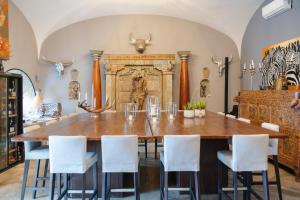 a dining room with a large wooden table and white chairs at Don Mario Resort adults only in Pantelleria