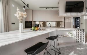a kitchen with white cabinets and a counter with stools at Beautiful Home In Srima in Srima