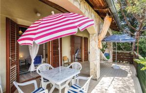 een tafel en stoelen en een parasol op een patio bij Two-Bedroom Apartment In Krusevo in Kruševo