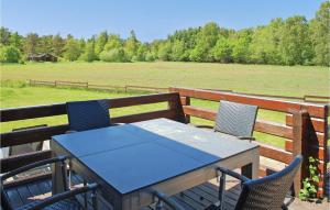 a table and chairs on a deck with a field at Holiday Home Kærsangervej Ebeltoft in Øksenmølle +24 photos