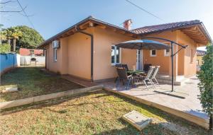 a patio with a table and an umbrella at 3 Bedroom Lovely Home In Savudrija in Savudrija