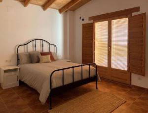 une chambre avec un grand lit et une fenêtre dans l'établissement La Llobatera Casa Rural, à Les Coves de Vinroma