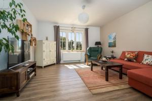 a living room with a red couch and a tv at Haus-kl-Mueritz in Rechlin