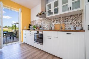 a kitchen with white cabinets and a view of a patio at Haus-kl-Mueritz in Rechlin