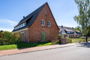 a red brick house with a green door on a street at Haus-kl-Mueritz in Rechlin