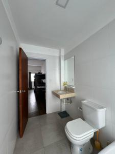 a bathroom with a toilet and a sink and a piano at ALPACA DEPARTAMENTOS in Cafayate +174 photos