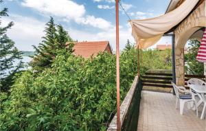 een terras met een tafel, stoelen en een parasol bij Two-Bedroom Apartment In Krusevo in Kruševo