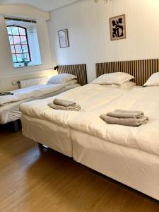 two beds in a room with towels on them at BB Esbjerg in Esbjerg