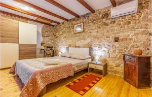 a bedroom with a bed and a stone wall at Holiday Home Kavran - 08 in Kavran