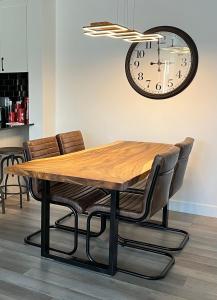 a dining room table with chairs and a clock on the wall at Joli condo en basse-ville - Parking gratuit 309357 in Quebec City