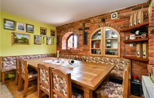 a dining room with a wooden table and a brick wall at Nice Home In Sedlarica With Sauna in Sedlarica