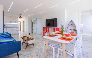 a living room with a dining table and a surfboard at Cozy Apartment In Guardamar Del Segura in Guardamar del Segura
