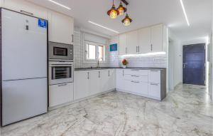 a white kitchen with white cabinets and appliances at Cozy Apartment In Guardamar Del Segura in Guardamar del Segura