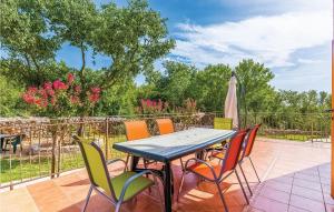 a table with chairs and an umbrella on a patio at Lovely Home In Garica With Wifi in Garica