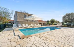 a swimming pool with chairs and an umbrella at Stunning Home In Unesic in Unešić