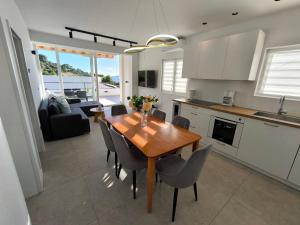 a kitchen and dining room with a wooden table and chairs at Astramaris Apartments in Okrug Donji