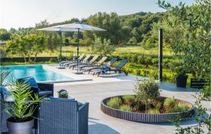 ein Swimmingpool mit Liegestühlen und Sonnenschirm in der Unterkunft Beach Front Home In Zdrelac in Ždrelac