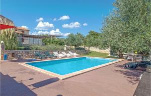 einen Pool im Garten mit Stühlen in der Unterkunft 4 Bedroom Amazing Home In Pavicini in Veliki Vareški