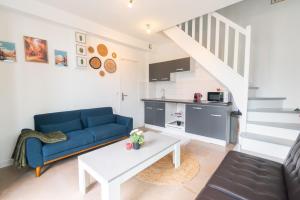 a living room with a blue couch and a table at Le Hangar Fleuri in Gagny