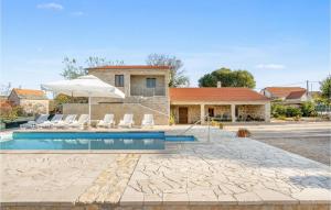 a villa with a swimming pool and a house at Stunning Home In Unesic in Unešić