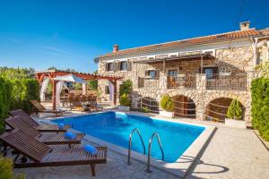 a villa with a swimming pool in front of a building at Villa Vita in Polje