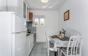 a kitchen with a white refrigerator and a table with chairs at 2 Bedroom Nice Apartment In Pinezici in Pinezici